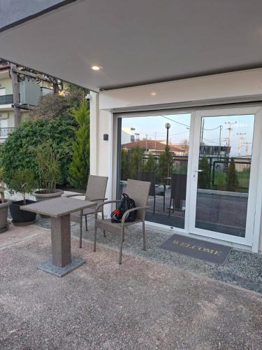 a patio with a table and chairs and a glass door at Good Holiday in Kallithea Halkidikis