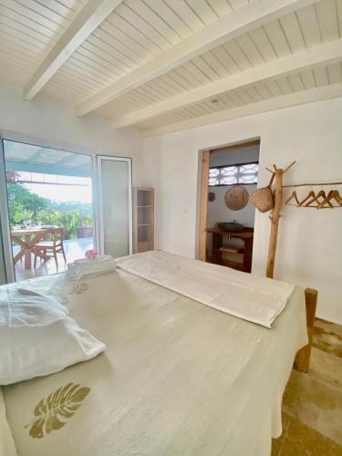 a large bed in a room with a large window at Charmant Bungalow Independant in Grand-Bourg