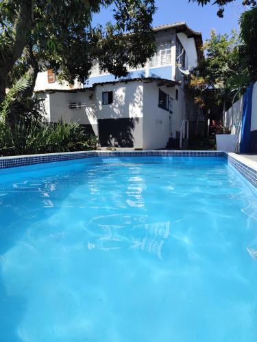 a large blue swimming pool in front of a house at Paraiso Mar in Búzios