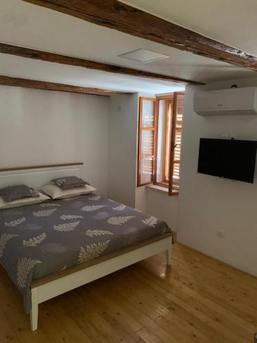 a bedroom with a bed and a flat screen tv at Luca in Račišće