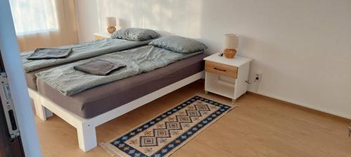 a bedroom with a bed with a night stand and a rug at Greengold in Săcădat