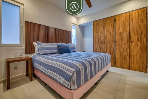 a bedroom with a large bed with a wooden headboard at New 1 BR Condo with Amazing Rooftop Pool - Jacuzzi in Bucerías