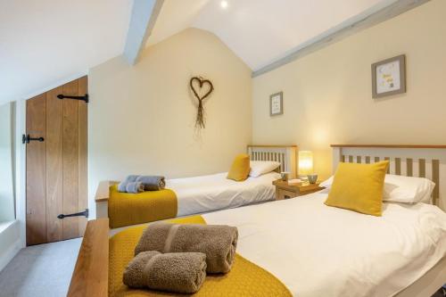 two beds in a bedroom with yellow pillows at 2 Bed in Abergele oc-88974 in Llanfair Talhaiarn