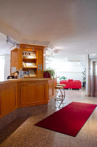 a kitchen with a counter and a red rug at Grunau Hotel in Bayreuth