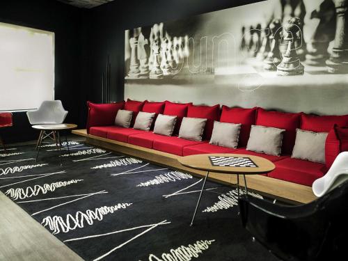 a red couch in a living room with a table at ibis Criciuma in Criciúma