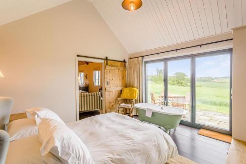 a bedroom with a bed and a tub and a window at 1 Bed in Wickhambrook oc-tosh in Wickhambrook