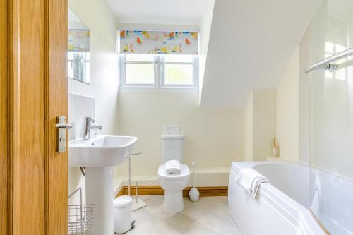 a white bathroom with a tub and a toilet and a sink at 5 Bed in Hanworth Common oc-1650 in Thurgarton
