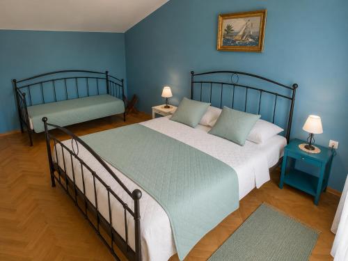 a bedroom with two beds and blue walls at Apartments Marko in Vodice