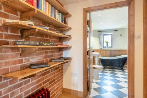 a room with a brick wall with bookshelves at 6 Bed in Wangford oc-e31107 in Wangford
