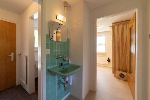 a bathroom with a green sink in a hallway at Churfirstenblick in Wildhaus