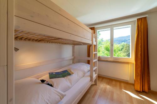 two bunk beds in a room with a window at Churfirstenblick in Wildhaus