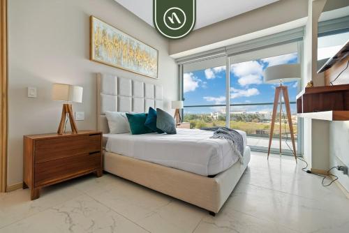 a bedroom with a large bed and a large window at New 2BR APT - Beach Access - Pool - GYM - Jacuzzi in Nuevo Vallarta