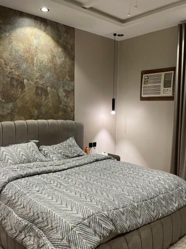 a bed in a bedroom with a painting on the wall at غرفه وصاله in Tabuk