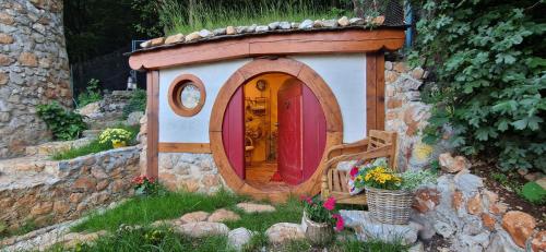 a small play house with a red door in a stone wall at Veža na vlásku in Háj