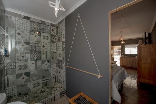 a bedroom with a wall covered in tiles at Die Moerbeiboom in Bloemfontein