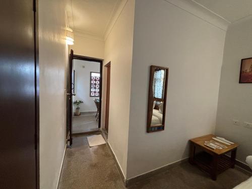 a hallway with a door and a mirror on a wall at L'EDELWEISS Heritage House in Pondicherry