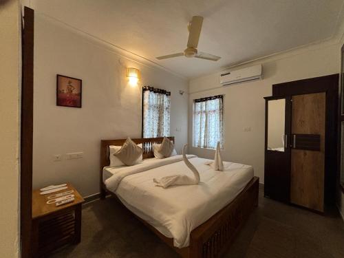 a bedroom with a large bed and a ceiling fan at L'EDELWEISS Heritage House in Pondicherry