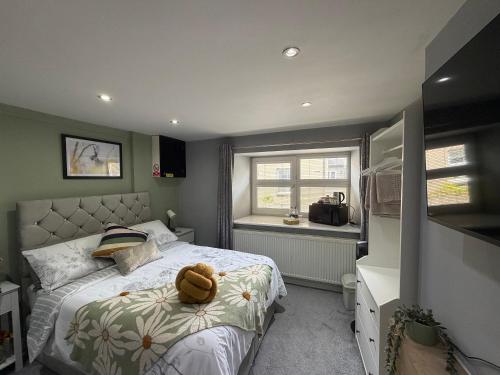 a bedroom with a bed with a teddy bear on it at Cottage 33 in Kirkby Stephen
