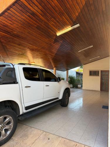 a white truck parked under a building with a wooden ceiling at Ampla Casa Duplex com 4 suítes in Teresina