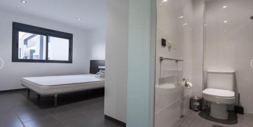 La salle de bains est pourvue d'un lit, de toilettes et d'une douche. dans l'établissement Oasis beach, à Playas de Orihuela