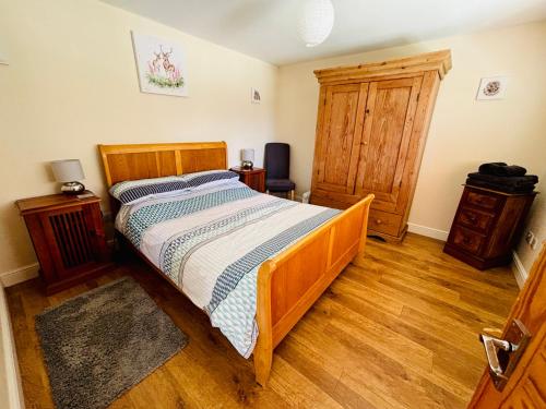 a bedroom with a wooden bed and a wooden floor at The Old Gate House Annexe in Alford
