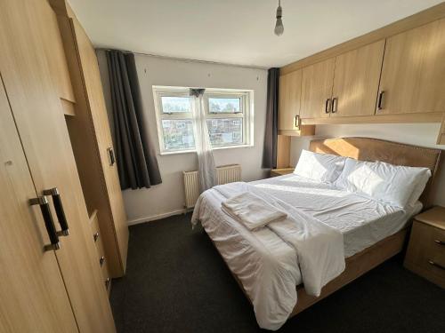 ein Schlafzimmer mit einem Bett mit weißer Bettwäsche und einem Fenster in der Unterkunft Warmark Road, Hemel Hempstead in Great Gaddesden