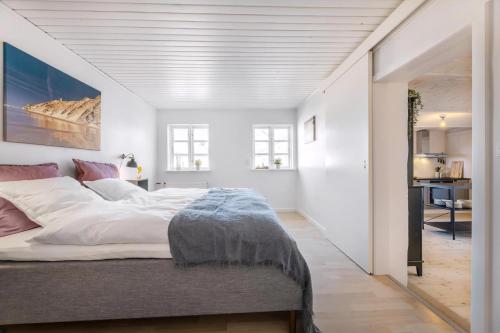 a bedroom with a large bed with white walls at Kostalden A Cozy Setting For Family Time in Hjørring