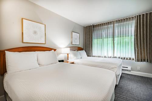 a hotel room with two beds and a window at La Residence Suite Hotel in Bellevue