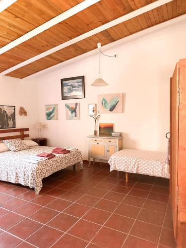 a room with two beds and a table in it at Casa Olivia Sant Lluis in Sant Lluis