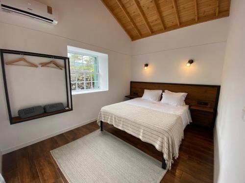 a bedroom with a bed and a mirror and a window at Refúgio da Montanha in Lajido