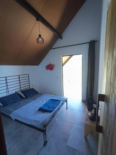 a bedroom with a bed and a large window at Chalé Punaras in Araruna