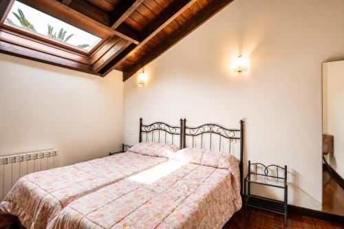 a bedroom with a bed and a window at Tejasturias |Piscina, Pádel y Playa de La Franca in Noriega