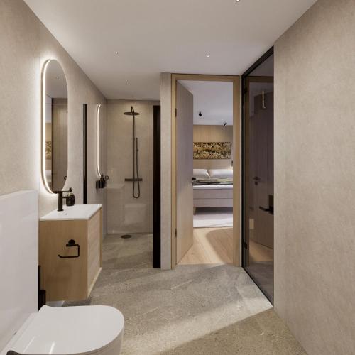 a bathroom with a toilet and a sink and a bed at Lyngen Experience Lodge in Nord-Lenangen