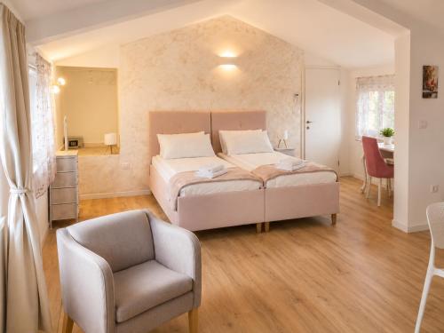 a bedroom with a bed and a chair at Villa Rosa dei Venti in Kaštel