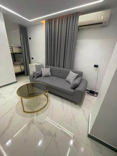 a living room with a couch and a glass table at Luxury king studio in 6th Of October