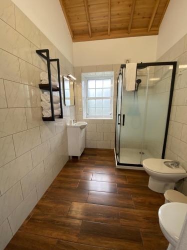 a bathroom with a shower and a toilet and a sink at Refúgio da Montanha in Lajido