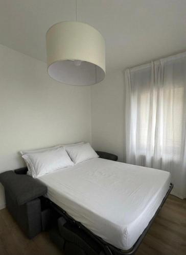 a bedroom with a white bed and a large light at Appartamento alla Lupa in Vetriola