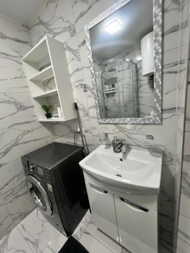 a bathroom with a sink and a television in it at Komarova in Chernivtsi