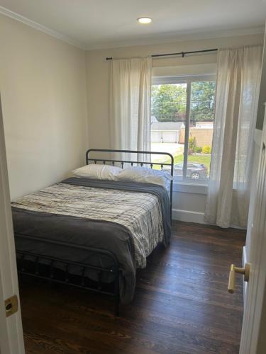 a bedroom with a bed and a large window at The Signature Stay in Clifton