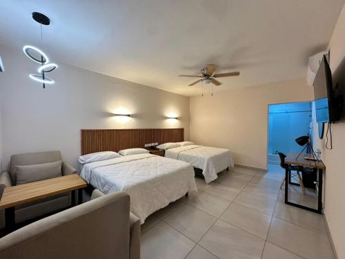 a hotel room with two beds and a couch at Hotel Maioris Kumate Culiacán in Culiacán