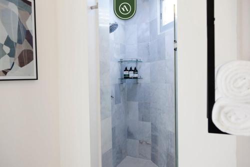 a shower with a glass door with bottles on a shelf at Ocean view 2BR Condo - Private Terrace - Beach in Nuevo Vallarta