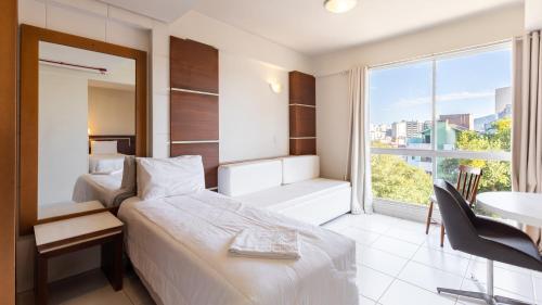 a hotel room with a bed and a desk and a window at Tri Hotel Executive Santa Maria in Santa Maria