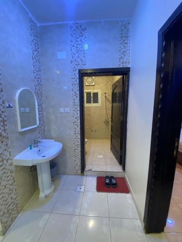 a bathroom with a sink and a toilet and a mirror at شقق برج أربعين واحد in Al Qurayyat