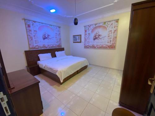 a bedroom with a bed in the corner of a room at شقق برج أربعين واحد in Al Qurayyat