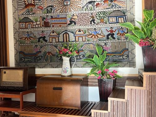 a mosaic wall with a vase on a table with flowers at Casa Salkantay Cusco in Cusco