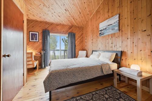 a bedroom with a bed and a wooden wall at Rustic Waterfront Kayak Near National Park in Tobermory