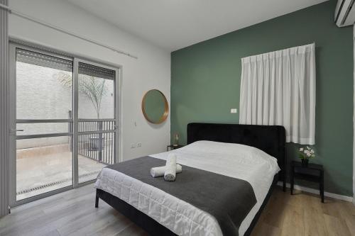 a bedroom with a bed and a large window at וילה מארי עם בריכה במגדל in Migdal
