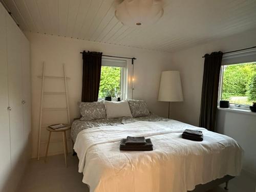 a bedroom with a large white bed and a window at Gunnegårds gästhus in Fleninge