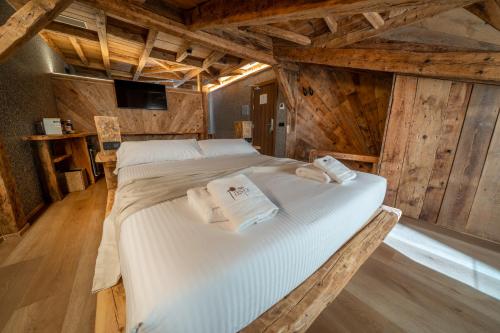 a large bed in a room with wooden walls at Hosteria Pastor in Aranda de Duero