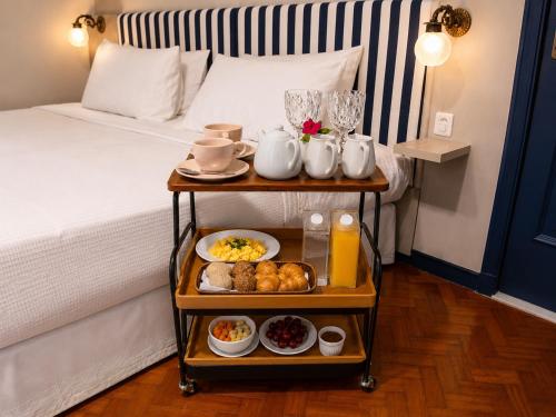 a hotel room with a bed with a tray of food at Altos de Colombo Guest House Boutique - Soft Opening in Rio de Janeiro